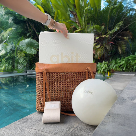 abit.of foldable yoga mat packed next to a bag and Pilates ball for travel