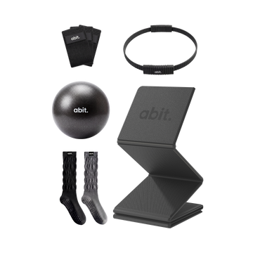 abit.of home Pilates kit flat lay showing resistance bands, Pilates ring, ball, grip socks and foldable mat