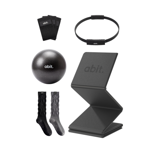 abit.of home Pilates kit flat lay showing resistance bands, Pilates ring, ball, grip socks and foldable mat